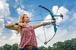 Young Woman Shooting Archery With Compound Bow And Arrow Stock Photo