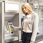 Young Woman Using Bank ATM Stock Photo