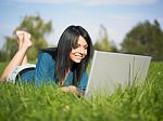 Young Woman Using Laptop In Park Stock Photo