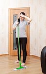 Young Woman Washes Floor With A Mop Stock Photo