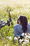 Young Woman With Mountain Bike Stretched On The Field Stock Photo
