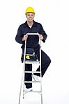 Young Worker Climbing Stepladder Stock Photo