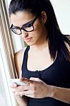 Young Worker Woman With Smartphone In Her Office Stock Photo