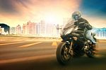 Younger Man Wearing Safety Helmet And Riding Suit  Biking Sport Motorcycle On Urban Road With Blurry Background Use For People Traveling And Sport Activity,leisure Stock Photo
